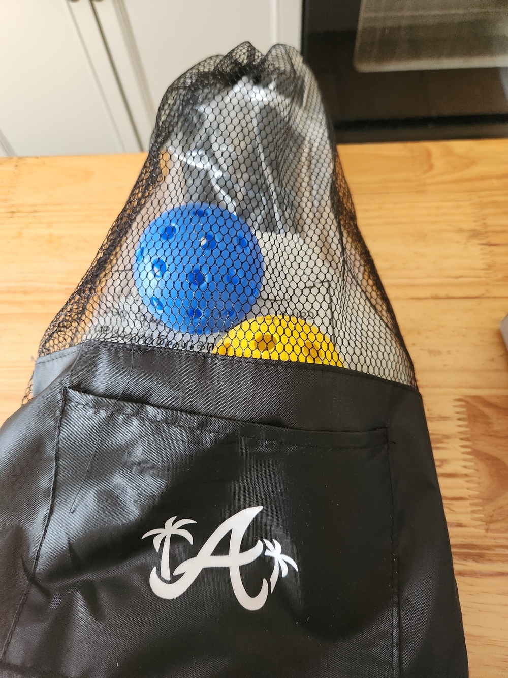 A Palm Logo Black Mesh Sports Drawstring Bag with Blue & Yellow Balls